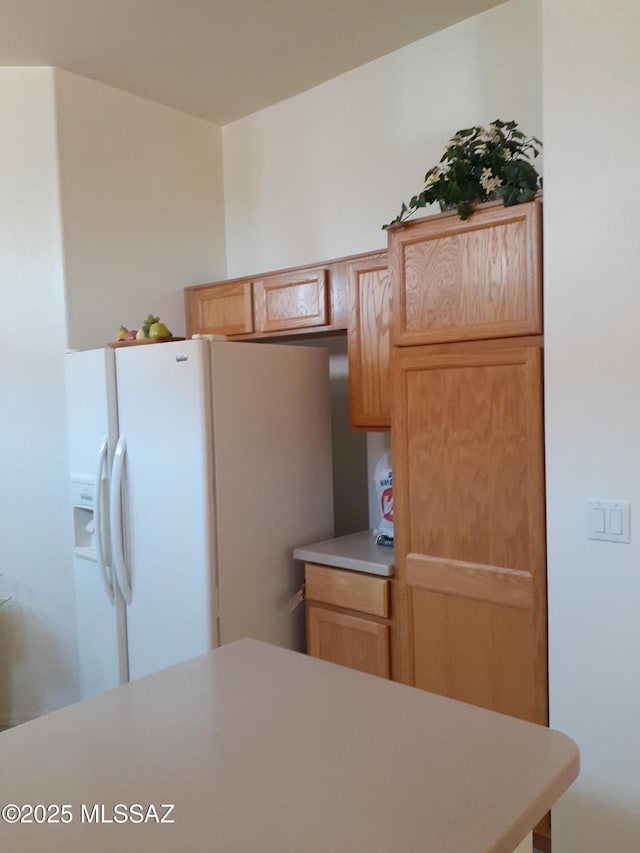 kitchen with light countertops and white fridge with ice dispenser