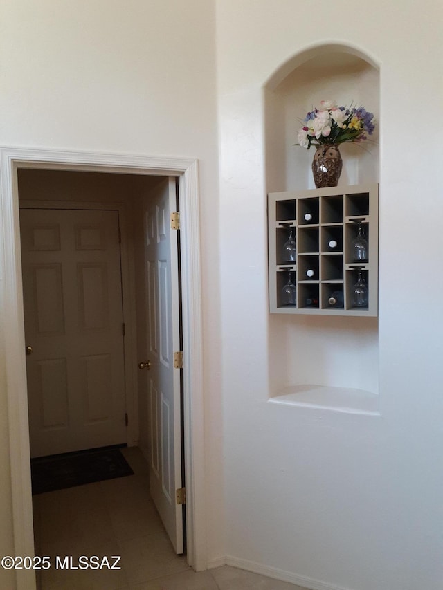 hall featuring tile patterned floors and baseboards
