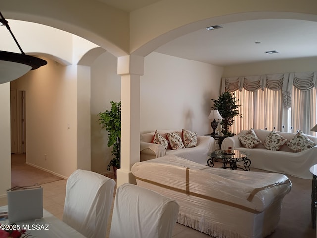 living area with arched walkways, visible vents, and baseboards