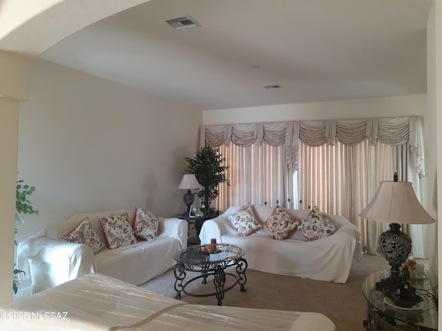living area with visible vents and carpet flooring