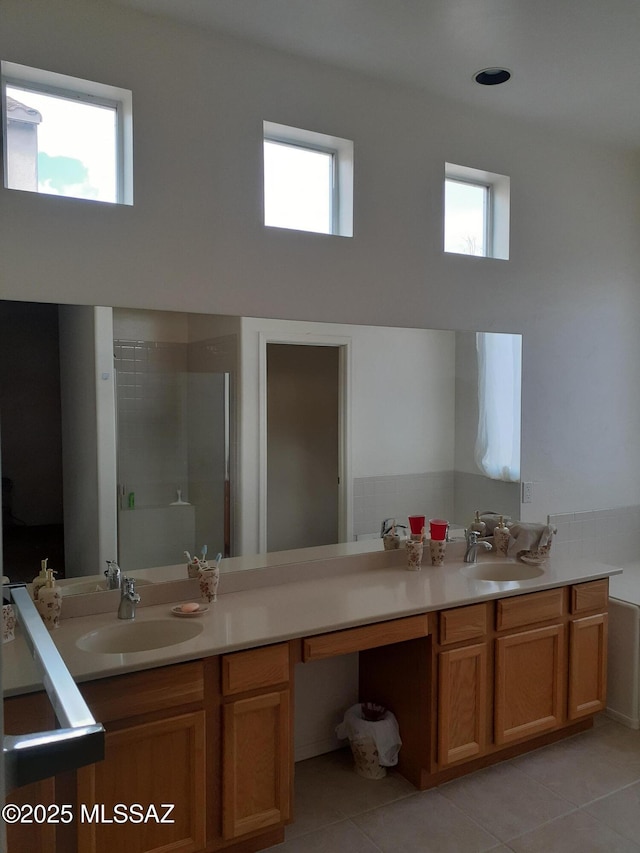 full bathroom with a wealth of natural light, tile patterned flooring, and a sink