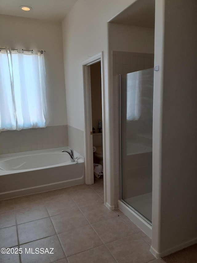 bathroom with a bath, a shower stall, tile patterned floors, and toilet