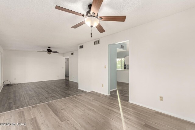 1363 W Dawn Dr, Tucson, AZ 85704 - unfurnished living room with a ceiling fan, wood finished floors, a textured ceiling, and baseboards