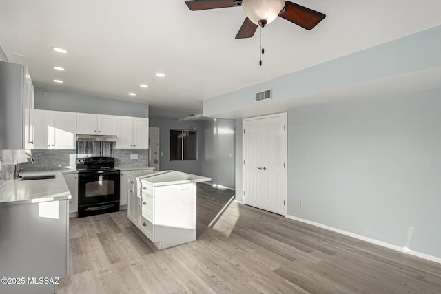 1363 W Dawn Dr, Tucson, AZ 85704 - kitchen with electric range, a sink, backsplash, light wood-style flooring, and a kitchen island