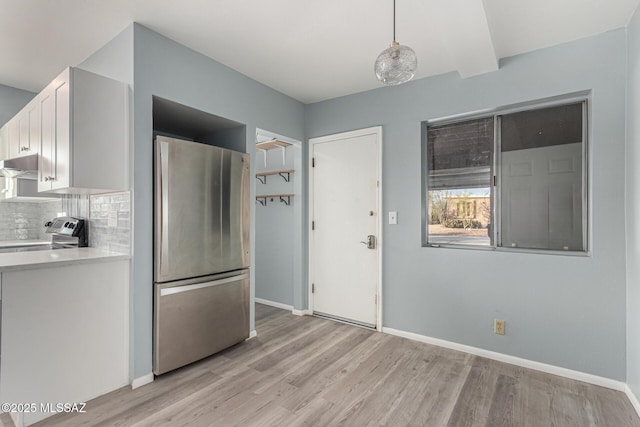 1363 W Dawn Dr, Tucson, AZ 85704 - kitchen with appliances with stainless steel finishes, under cabinet range hood, light countertops, light wood finished floors, and white cabinets