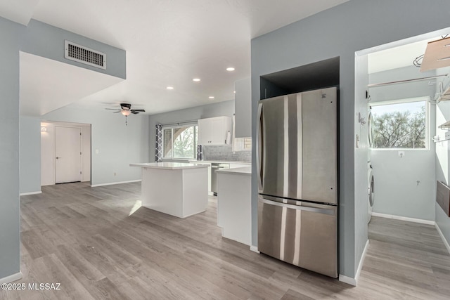 1363 W Dawn Dr, Tucson, AZ 85704 - kitchen with appliances with stainless steel finishes, white cabinets, light countertops, a kitchen island, and light wood-style floors