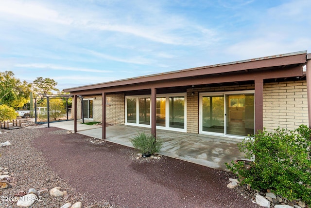 1363 W Dawn Dr, Tucson, AZ 85704 - back of house featuring a patio and brick siding