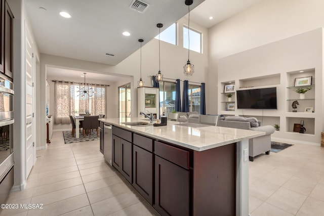 kitchen featuring visible vents, a sink, light tile patterned flooring, a chandelier, and built in features