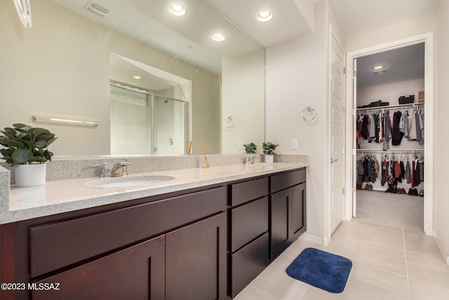 bathroom with tile patterned floors, double vanity, visible vents, a sink, and a stall shower