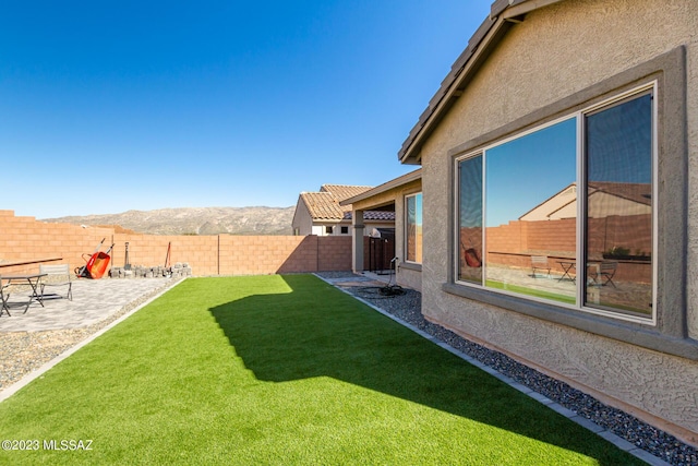 view of yard featuring a mountain view, a patio, and fence private yard