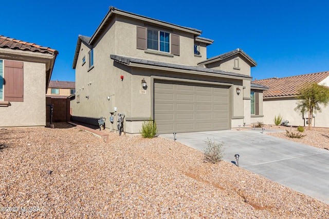traditional-style house with stucco siding, an attached garage, and concrete driveway