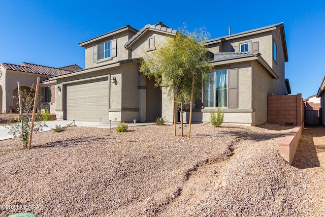 view of front of house with a tile roof, driveway, fence, a garage, and stucco siding