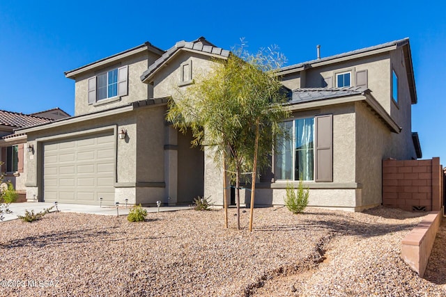 traditional-style home with a tiled roof, driveway, fence, an attached garage, and stucco siding