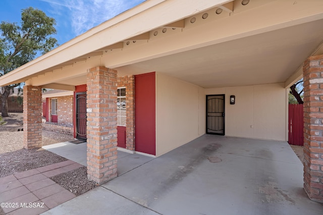 2991 W Basil Pl, Tucson, AZ 85741 - doorway to property with a carport, brick siding, and fence