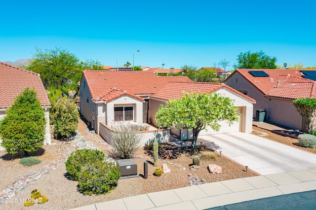 mediterranean / spanish-style home featuring concrete driveway, a garage, stucco siding, and a tiled roof