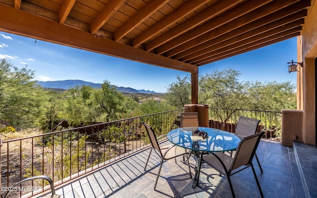 balcony featuring a mountain view and outdoor dining area