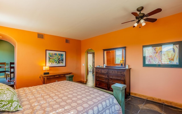 bedroom with visible vents, arched walkways, baseboards, and vaulted ceiling