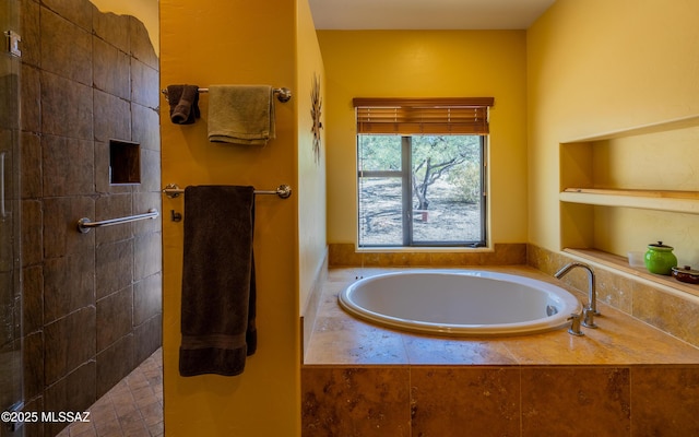 full bathroom featuring a garden tub and a tile shower