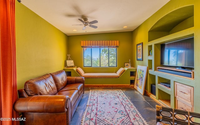living room with baseboards and a ceiling fan