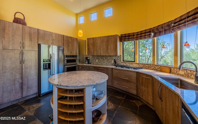 kitchen featuring appliances with stainless steel finishes, open shelves, a sink, light stone counters, and a high ceiling