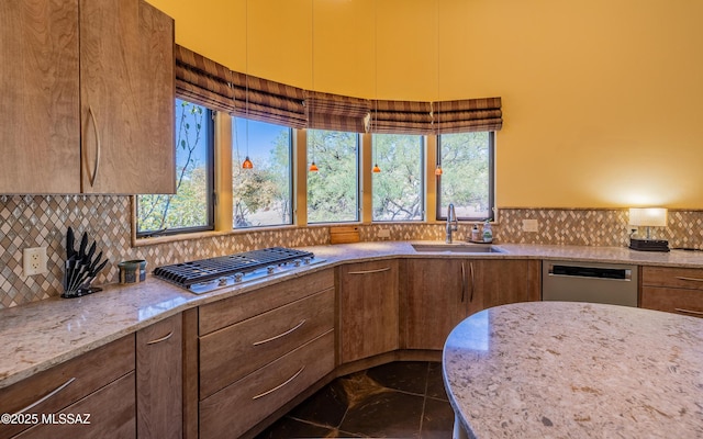 kitchen featuring a sink, appliances with stainless steel finishes, tasteful backsplash, and a healthy amount of sunlight