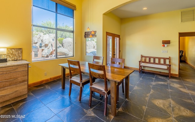 dining area featuring arched walkways, baseboards, visible vents, and french doors