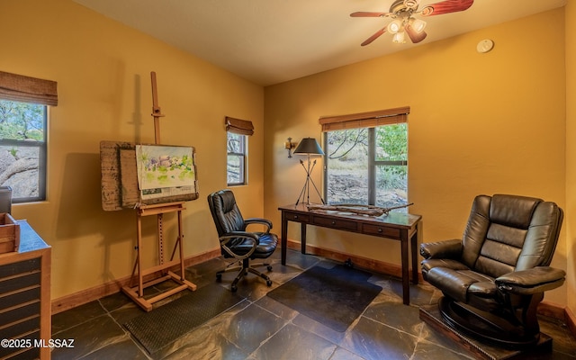 living area featuring ceiling fan and baseboards