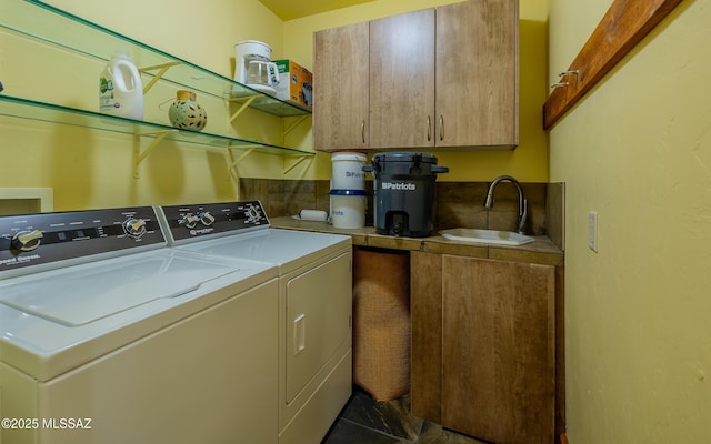 clothes washing area featuring a sink, cabinet space, and washer and dryer