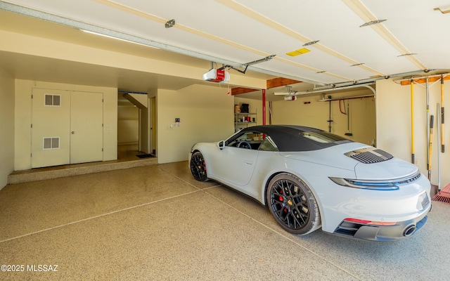 garage featuring a garage door opener and visible vents