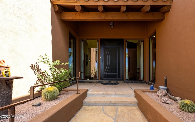 entrance to property featuring stucco siding