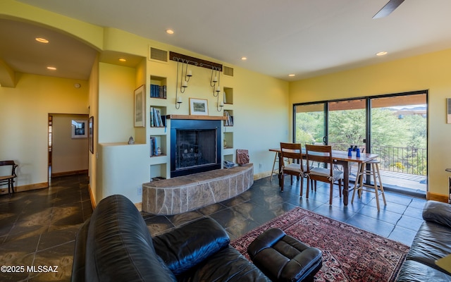 living area with baseboards, visible vents, and a tile fireplace