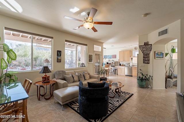 3033 W Desert Glory, Tucson, AZ 85745 - living area featuring arched walkways, baseboards, visible vents, ceiling fan, and light tile patterned floors