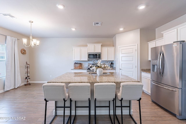 kitchen featuring a notable chandelier, visible vents, white cabinetry, and stainless steel appliances