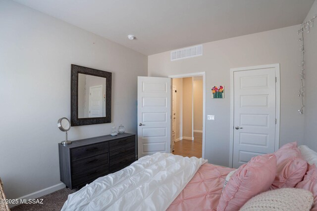 bedroom featuring baseboards and visible vents