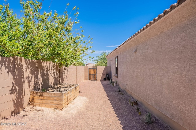 view of yard with a gate, fence private yard, and a garden
