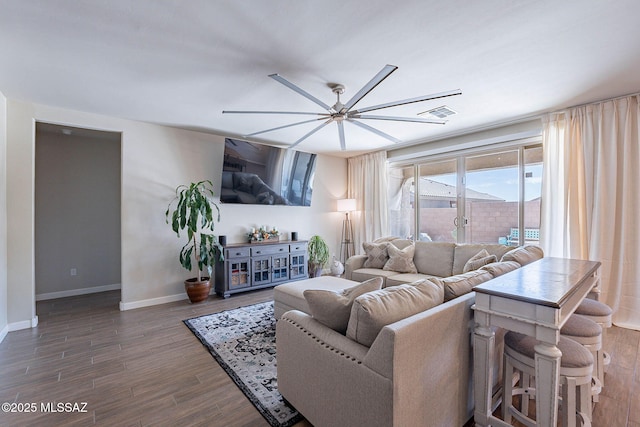 living room with baseboards, wood finished floors, and ceiling fan