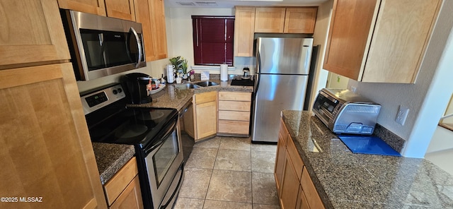 6651 N Campbell Ave Apt 152, Tucson, AZ 85718 - kitchen featuring appliances with stainless steel finishes, a sink, dark stone countertops, light tile patterned floors, and light brown cabinets