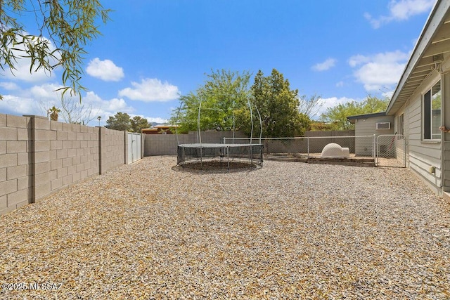 view of yard with a fenced backyard and a trampoline
