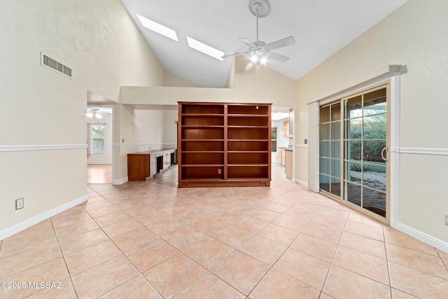 unfurnished living room with light tile patterned floors, a skylight, ceiling fan, and visible vents