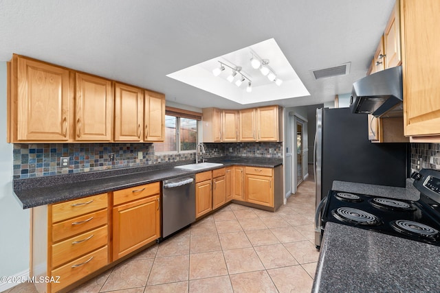 kitchen with appliances with stainless steel finishes, wall chimney range hood, a sink, visible vents, and a tray ceiling