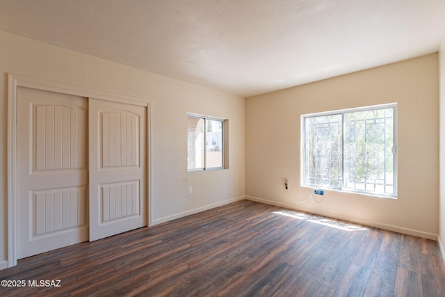 912 S Las Lomas Cir, Green Valley, AZ 85614 - unfurnished bedroom with dark wood-style floors, a closet, multiple windows, and baseboards