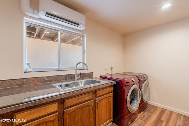912 S Las Lomas Cir, Green Valley, AZ 85614 - laundry area featuring a sink, baseboards, washer and clothes dryer, light wood finished floors, and a wall mounted AC