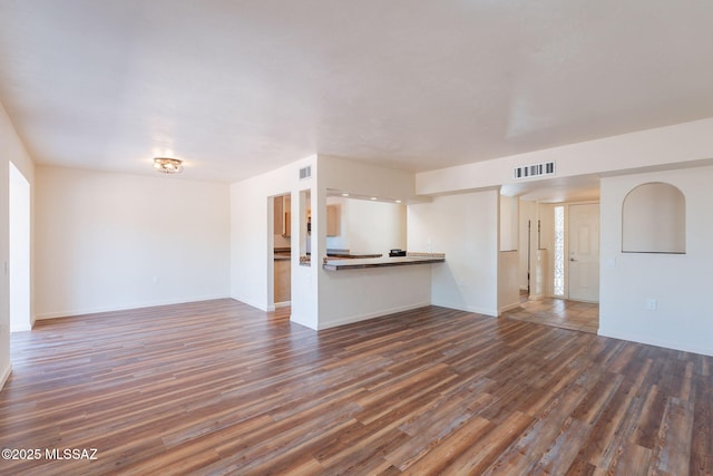 912 S Las Lomas Cir, Green Valley, AZ 85614 - unfurnished living room featuring visible vents, dark wood-style floors, and baseboards