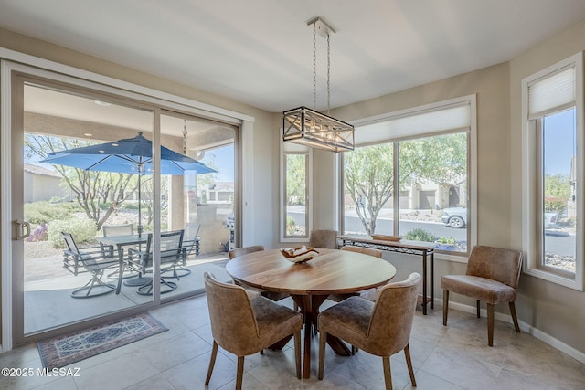 dining room featuring baseboards, a chandelier, and light tile patterned floors