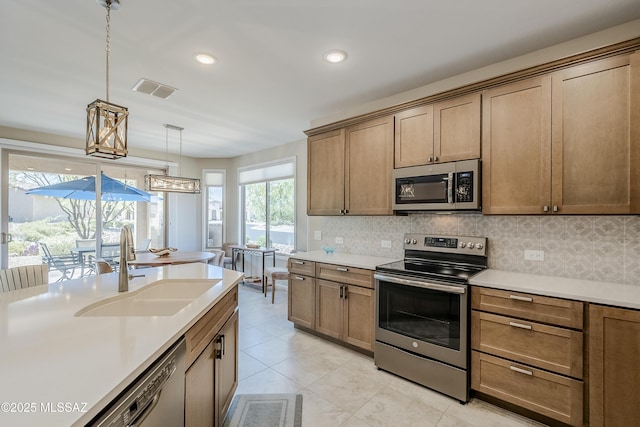 kitchen with backsplash, stainless steel appliances, visible vents, and a sink