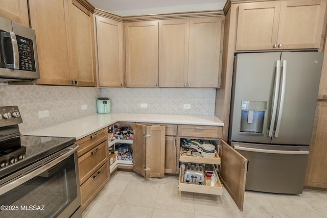 kitchen with decorative backsplash, light tile patterned floors, appliances with stainless steel finishes, and light countertops