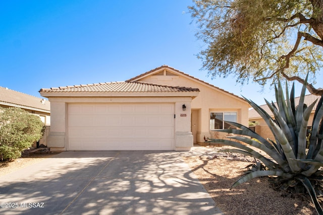 single story home featuring an attached garage, a tiled roof, driveway, and stucco siding