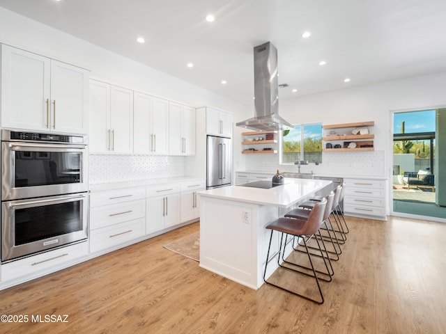 2540 W Oasis Springs Ct, Tucson, AZ 85742 - kitchen with backsplash, island exhaust hood, appliances with stainless steel finishes, open shelves, and white cabinetry