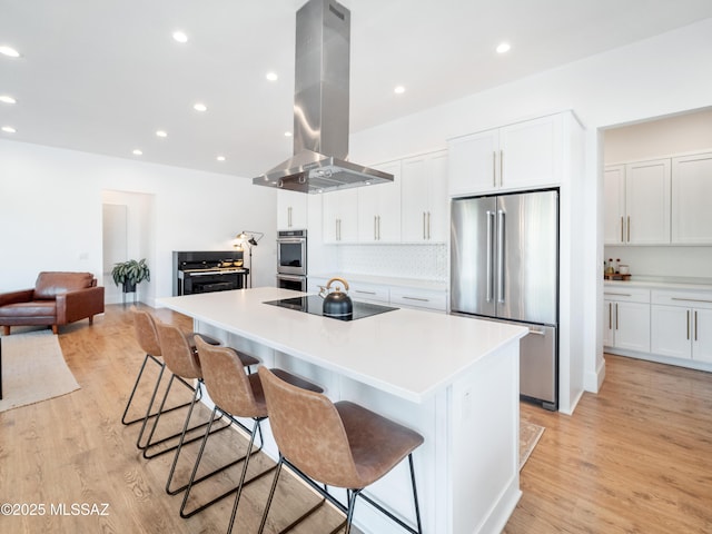 2540 W Oasis Springs Ct, Tucson, AZ 85742 - kitchen with appliances with stainless steel finishes, an island with sink, island exhaust hood, and a breakfast bar