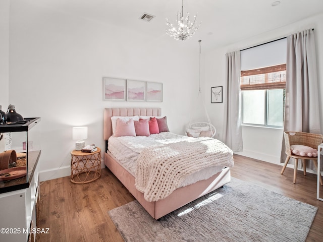 2540 W Oasis Springs Ct, Tucson, AZ 85742 - bedroom featuring a chandelier, baseboards, visible vents, and wood finished floors